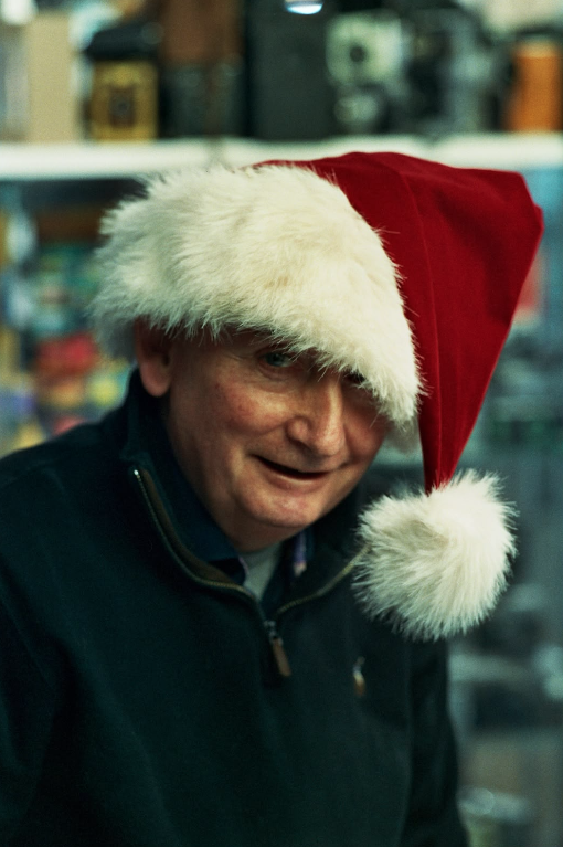 Doug wearing a Santa hat behind the counter at Camera Centre UK in Cardiff