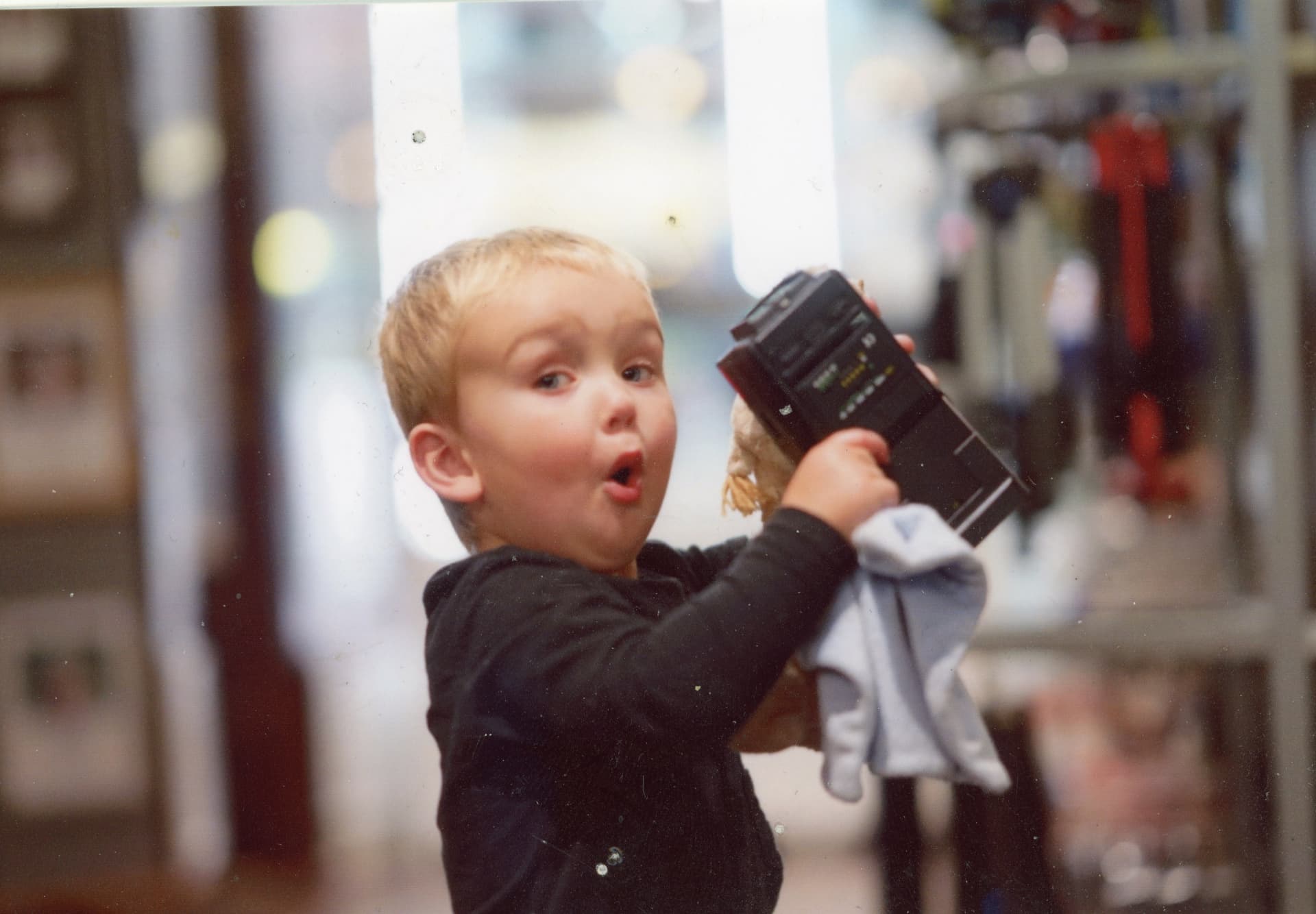 Charlie, aged around two, playing with an old flash gun in the Camera Centre UK shop in Morgan Arcade