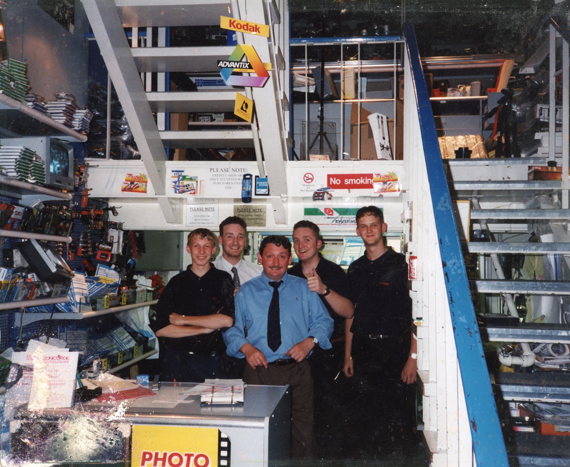 Camera Centre UK staff behind the counter in the 1990s with Kodak and Advantix signage overhead